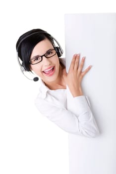 Pretty young call center worker wearing a headset and holding blank sign board