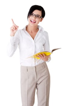 Happy young woman (student or teacher) with book in hand showing on copy space. Isolated on white.