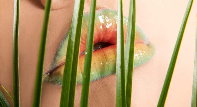 Woman's lips with green leafs