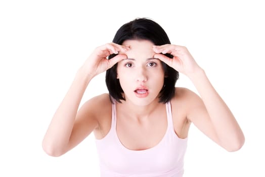 Beautiful shocked woman checking her wrinkles on her forehead