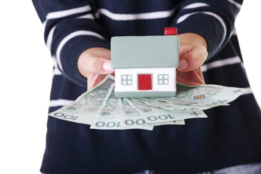 Woman holding PLN ( polish zloty ) bills and house model over white - real estate loan concept