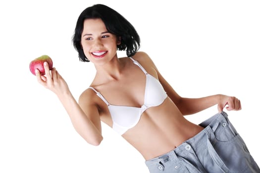 Young woman showing how much weight did she lost after fruit diet. Isolated on white