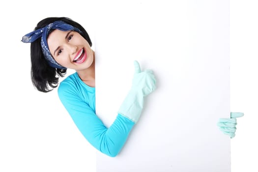 Smiling happy cleaning woman showing blank sign board.