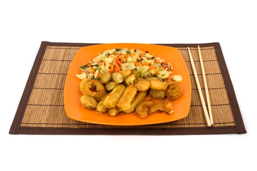Plate full of seafood and chopsticks on a natural reed pad. Isolated on pure white.