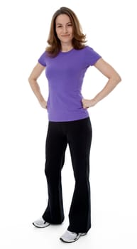Woman dressed in sportswear with hands on hips, standing on white background.