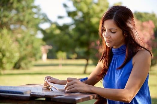 Young women and education, female student studying for college exam in park. Side view, copy space