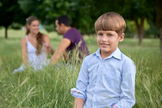 People and recreation, happy boy with mother and father in background. Front view