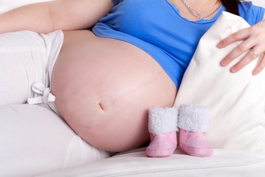 Pregnant woman with baby shoes