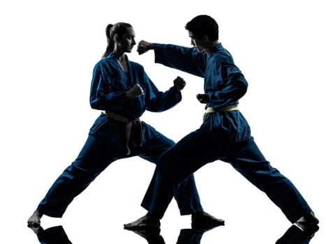 one  man woman couple exercising karate vietvodao martial arts in silhouette studio isolated on white background