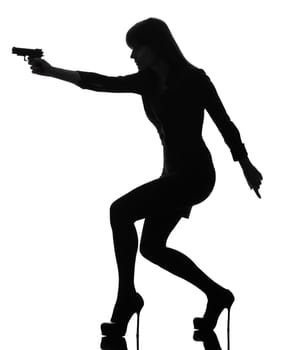 one caucasian sexy detective  woman holding aiming  gun in silhouette studio isolated on white background