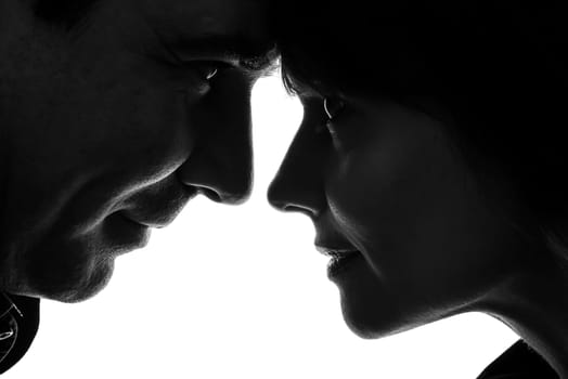one caucasian couple woman man lovers kissing    in silhouette studio isolated on white background