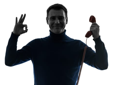 one causasian man on the phone ok sign portrait in silhouette studio isolated on white background