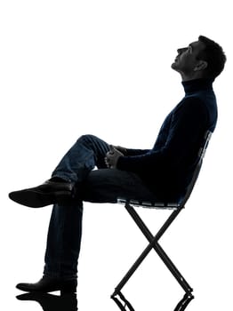 one causasian man reading book full length in silhouette studio isolated on white background