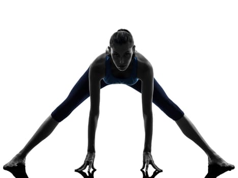 one caucasian woman exercising yoga stretching legs warm up in silhouette studio isolated on white background