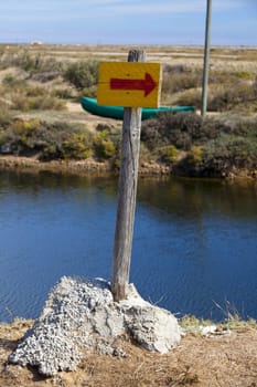 Simple signpost made of wooden stake and board with hand-painted arrow