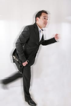 Full length of business man with briefcase running on white background