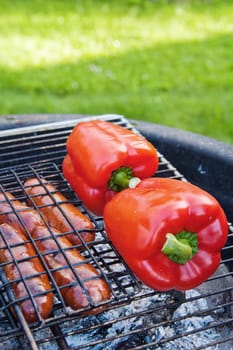 Red sweet pepper and sausages on a grill