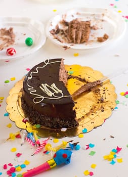after end of child birthday party with half chocolate cake slices and confetti
