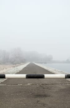 road to far away with barrier on freeze hoarfrosted landscape