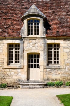 Historical building entrance door with vintage windows and brick roof