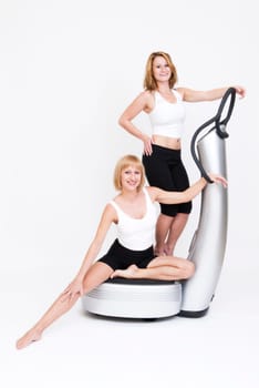 Two young women doing exercises on a powerplate