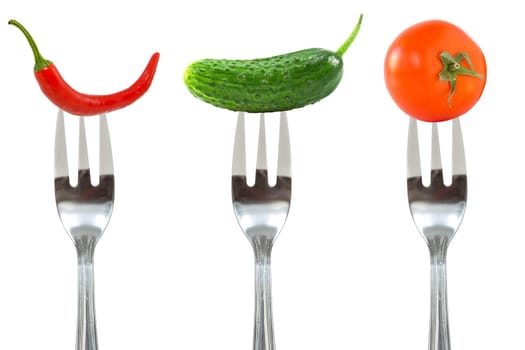 Diet concept. Vegetables on the forks, isolated over a white background.