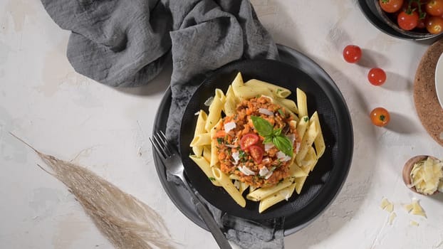 Vegetarian lentil Bolognese sauce penne pasta on a dark background. Healthy eating concept.