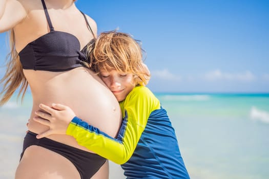 A radiant pregnant mother and her excited son share a tender moment on a serene, snow-white beach, celebrating family love amidst nature's beauty.