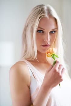 Portrait, woman and holding of flower in bedroom for romance with headshot in Norway. Female person, looking and hand with rose for love, trust or care in relationship for growth, bond and partner.