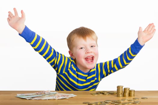 Cheering boy sitting in front of coins and bills