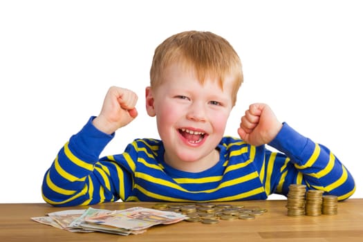 Cheering boy sitting in front of coins and bills