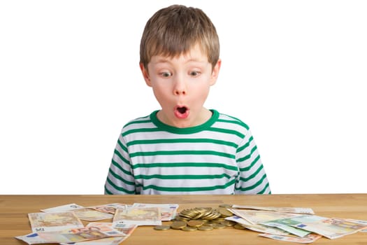 Boy sits in amazement in front of coins and bills