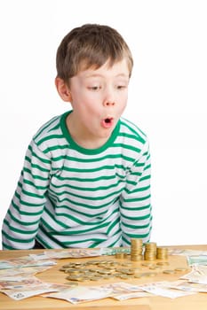 Boy amazed at a lot of money - coins and notes