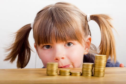 Girl looking at money towers - lying on the table
