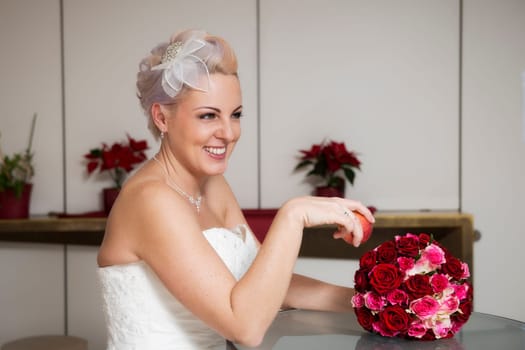 A bride laughingly holds an apple and a bridal bouquet in her hand