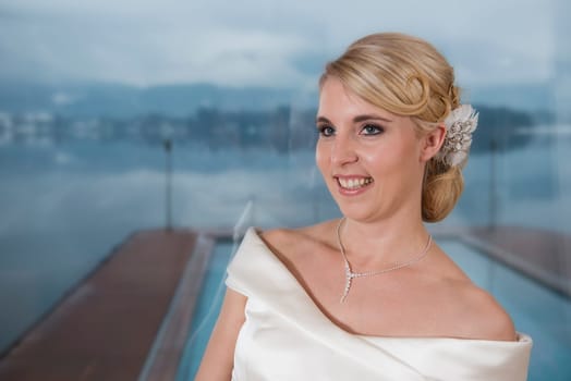 Portrait of a blonde bride with headdress,in front of Lake Wolfgang