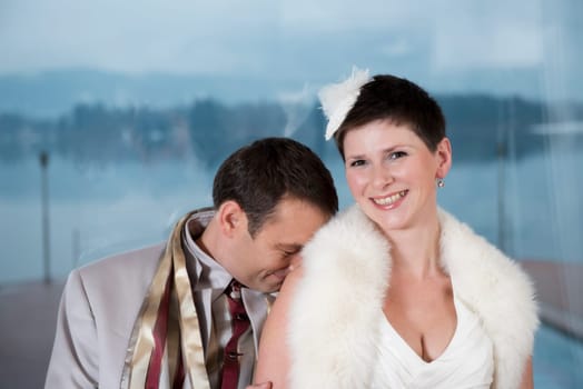 A bride and groom laugh and the groom hides bashfully