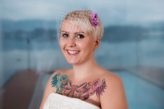 Portrait of a blonde bride with tattoo,in front of Lake Wolfgang