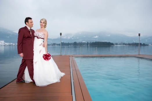 Young couple standing by the swimming pool in the lake of the White Horse Inn on Lake Wolfgang
