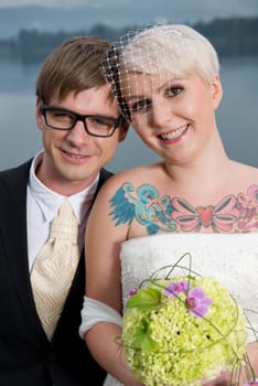 A young blonde bride with a tattoo and her groom