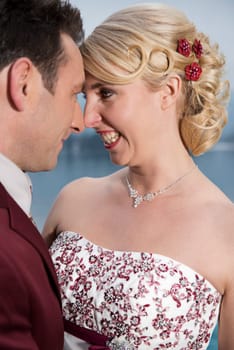 Portrait of a laughing young blonde bride with hair accessories with her husband
