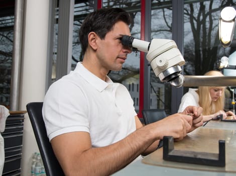 Two dental technicians at their workplace polishing dental prosthesis