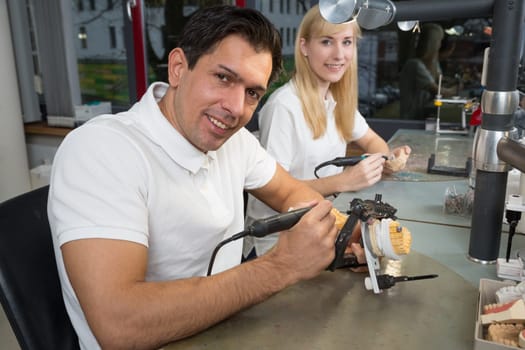 Dental technician working on a dental prosthesis in an articulator