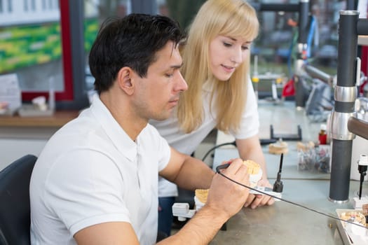 Instructor in a dental lab instructing an apprentice