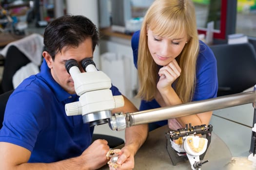 Dental technicians producing dental prosthesis under the microscope