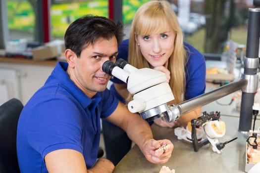 Dental technicians producing dental prosthesis under the microscope