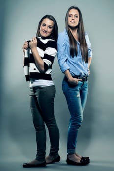 Two female teenagers in front of gray background