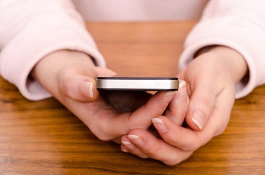 Two hands of a woman holding a smartphone