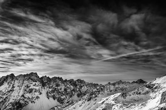 Winter mountains landscape with dark blue cloudy sky