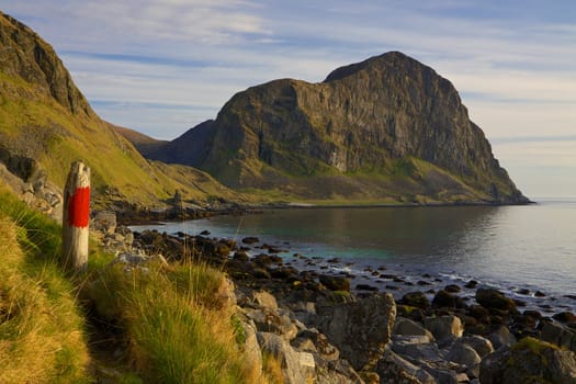 Coastline of island Vaeroy on Lofoten islands in Norway with dominant cliff
